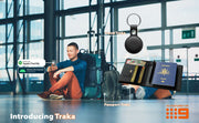 Man sitting with luggage at an airport, featuring Traka products including a travel tracker and Passport Traka.