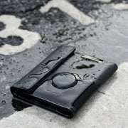 Black wallet with water droplets on a wet pavement