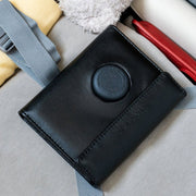 Black leather passport wallet on a light gray surface