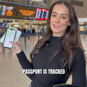 Woman holding a phone displaying a tracking map and a passport wallet at an airport.
